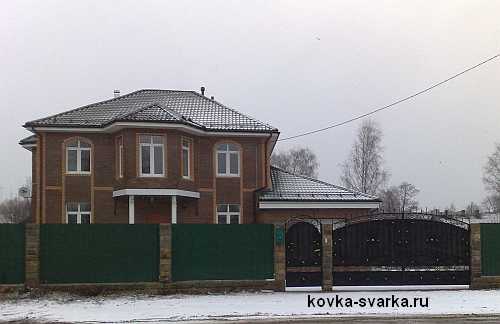 кирпичный дом и кованые ворота
